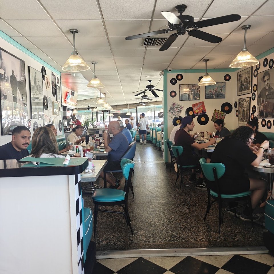 Casual diner dining room with booth tables and stools.